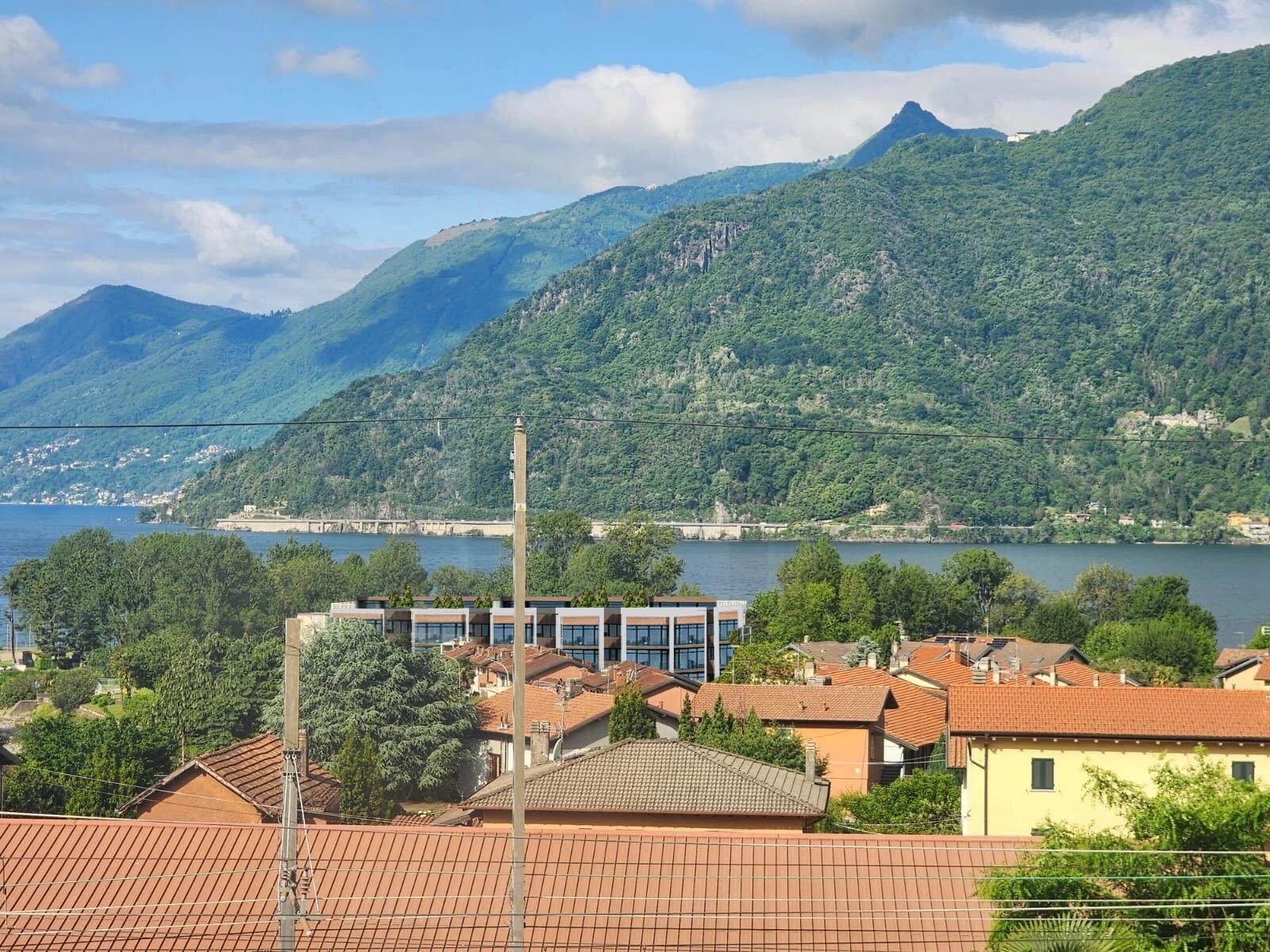 Lake Maggiore · Proposed residence within the townscape, with Lake Maggiore beyond — architectural visualisation.