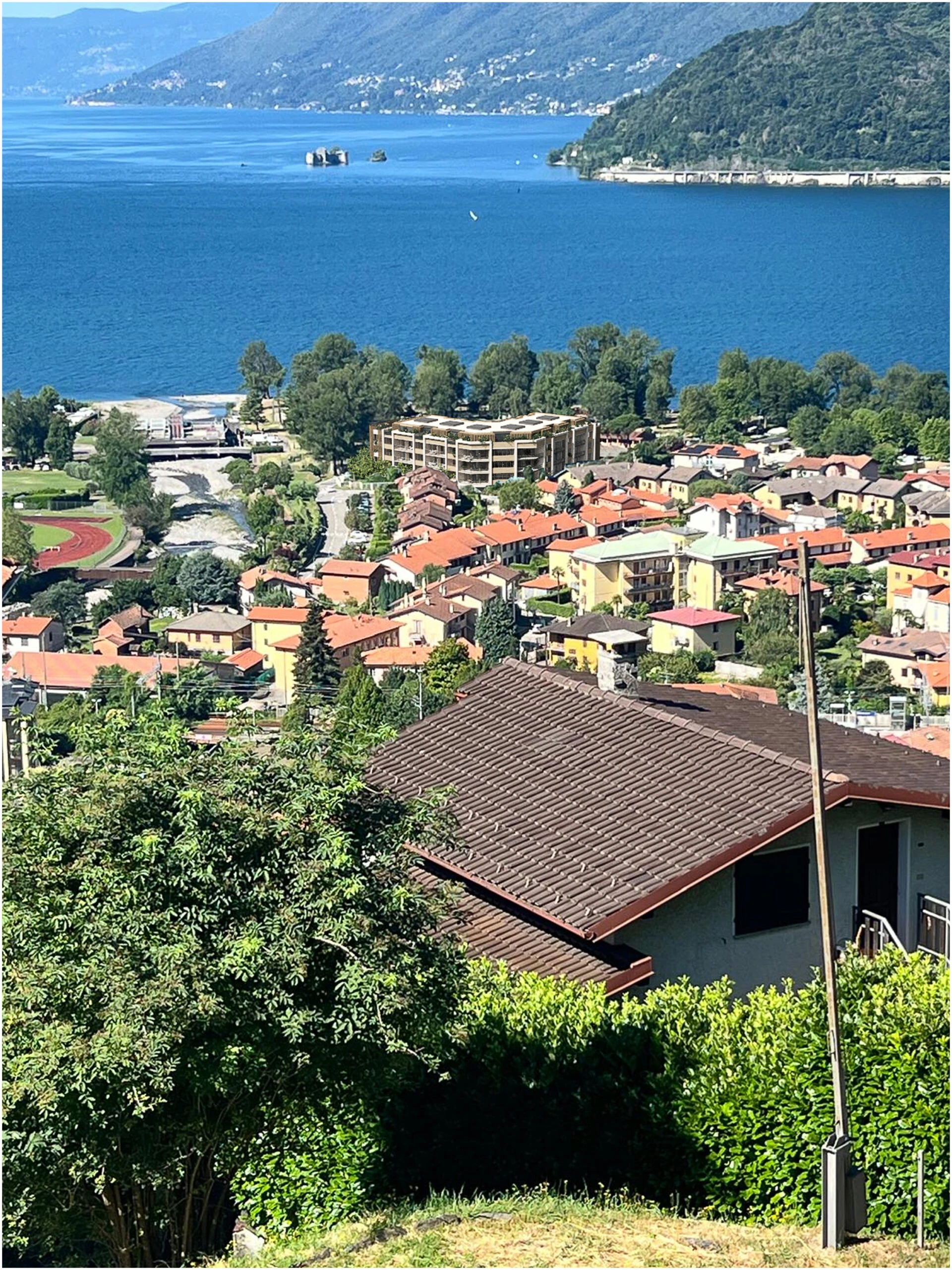 Lake Maggiore · Maccagno rooftops and Lake Maggiore — destination context, not a view from an apartment.